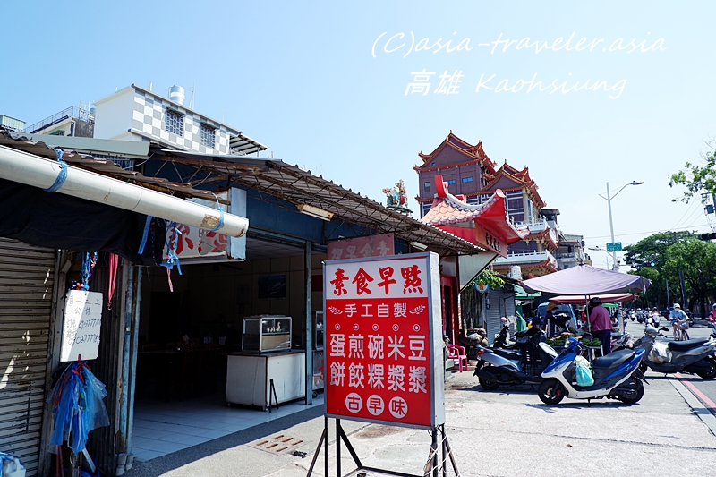 高雄の街角に立つ素食早点の赤い看板と廟